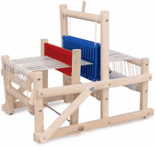 a wooden weaving loom with a red and blue divider