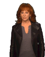 a woman with red hair is wearing a black jacket