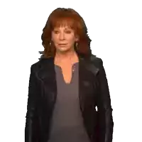 a woman with red hair is wearing a black jacket