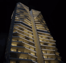 a very tall building with a lot of windows and balconies lit up at night