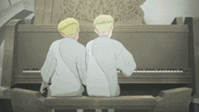 two men are sitting at a piano looking at the keyboard