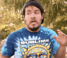 a man wearing a sublime t-shirt making a funny face