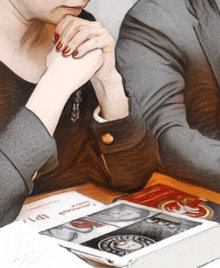 a woman sits at a table with her hands folded in front of a book that says ' tarot ' on it