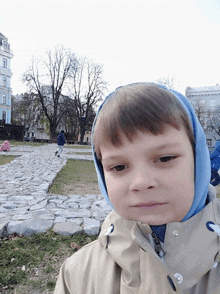 a young boy wearing a blue scarf around his head