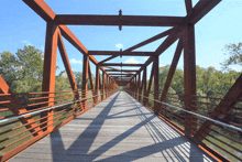 a bridge over a body of water with trees on the side