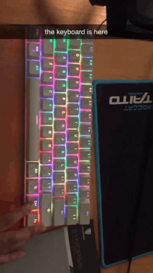 a keyboard is sitting on a desk next to a mouse pad that says duel