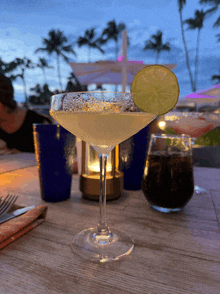 a margarita in a martini glass with a lime slice