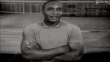 a black and white photo of a man with his arms crossed and the words boxing hall of fame behind him