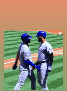 two baseball players are holding hands on the field