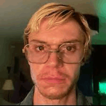 a close up of a man wearing glasses making a face .