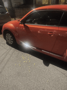 a red car is parked on a gray asphalt road