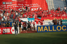 a group of people standing in front of a sign that says malloc