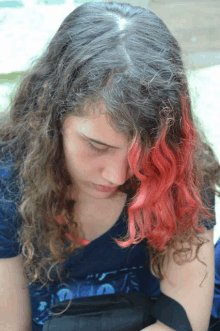 a woman with red hair is wearing a blue shirt with a shark on it