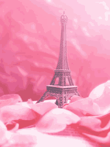 a model of the eiffel tower is surrounded by pink petals