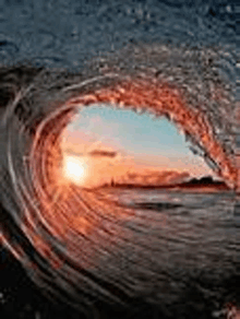 a view of a sunset through a wave .