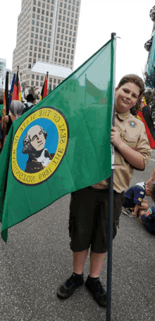 a boy scout is holding a green flag that says " the state of washington " on it