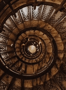 looking up at a spiral staircase with a circular design .