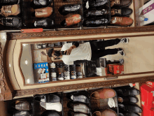 a man is taking a picture of himself in a mirror in a shoe shop