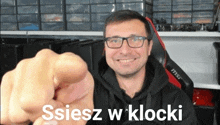 a man wearing glasses is pointing at the camera with the words " ssiesz w klocki " written above him