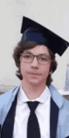 a young man wearing a graduation cap and gown and tie .