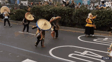 a group of people wearing sombrero hats are walking down a street in front of a sign that says comx