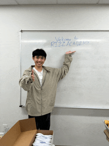 a man stands in front of a whiteboard that says welcome to rizzacademy