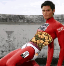 a man is painted red and has mixed nuts on his body