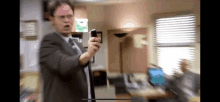 a man in a suit and tie is holding a cell phone in his hand