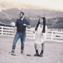 a man and a woman are dancing on a dirt field .