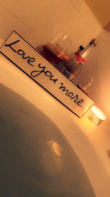 a bathtub with a sign that says " love you more " on it