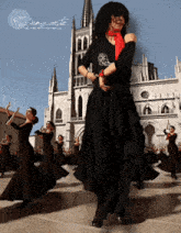 a group of flamenco dancers are performing in front of a large building with the words " la danza arte " on the bottom