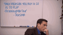 a man is sitting in front of a whiteboard that says " only reason you buy a co is to flip drinking milk tea "