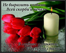 a white candle sits next to a bouquet of red flowers