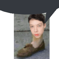 a blurry picture of a boy 's face with a shoe in the foreground