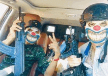 two people wearing clown masks and holding guns in a car .