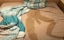 a bed with a wet blanket and pillow on it