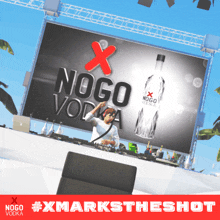 a bottle of nogo vodka is displayed in front of a large screen