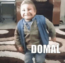 a little boy wearing a blue vest and a green sweater with the word domal written on the bottom