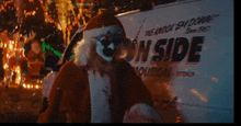 a man dressed as santa claus is standing in front of a white van that says ' nside ' on it