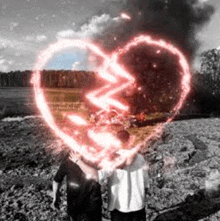 a couple of people standing next to each other with a glowing heart in the background .