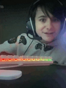 a young boy wearing headphones is sitting at a desk with a keyboard