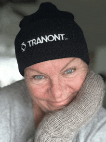 a woman wears a black beanie that says tranont