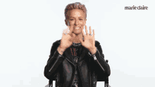 a woman with pink hair is giving the ok sign in front of a marie claire logo