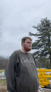 a man with a beard wearing a cabelas shirt