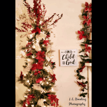 a sign that says i am a child of god hangs on a wall next to a christmas tree