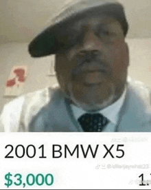 a man wearing a hat and tie is selling a 2001 bmw x5 for $ 3,000