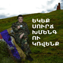 a man in a military uniform sits on a rock holding a cup of coffee in a field