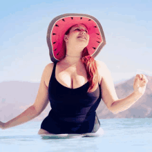 a woman in a black bathing suit and a watermelon hat