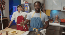 a man and a woman are cooking in a kitchen and the man is wearing an apron that says ' chef ' on it