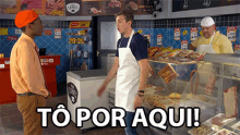 a man in an apron stands in front of a display case with the words to por aqui written on the bottom